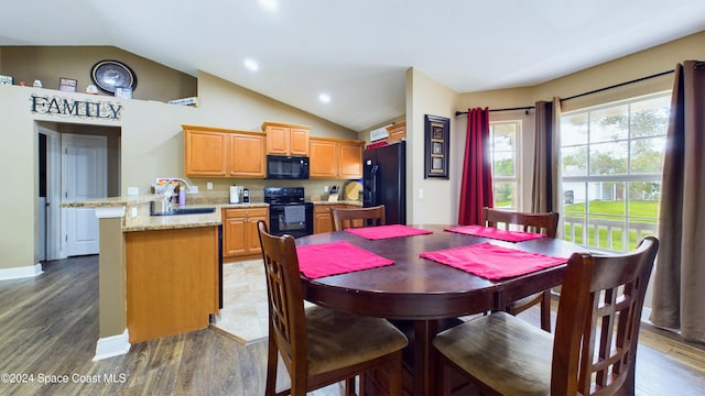 dining area featuring dark hardwood / wood-style flooring, sink, and vaulted ceiling