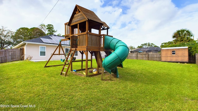 view of playground featuring a storage unit and a yard