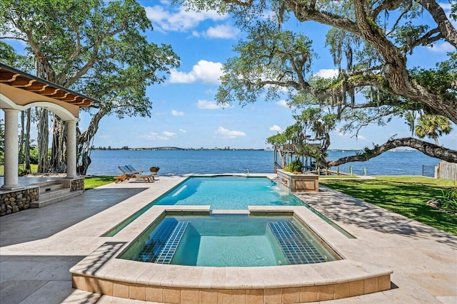 view of pool with a yard, a patio area, an in ground hot tub, and a water view