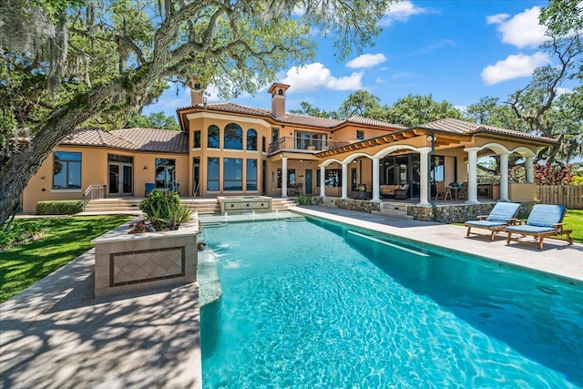 808 N Riverside Dr, Indialantic, FL 32903 - rear view of house featuring a chimney, a patio, stucco siding, a tile roof, and an outdoor pool