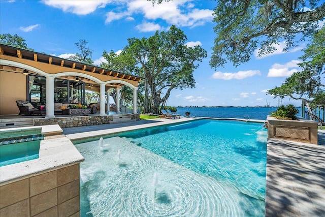 view of pool featuring a patio, ceiling fan, pool water feature, a water view, and an outdoor living space