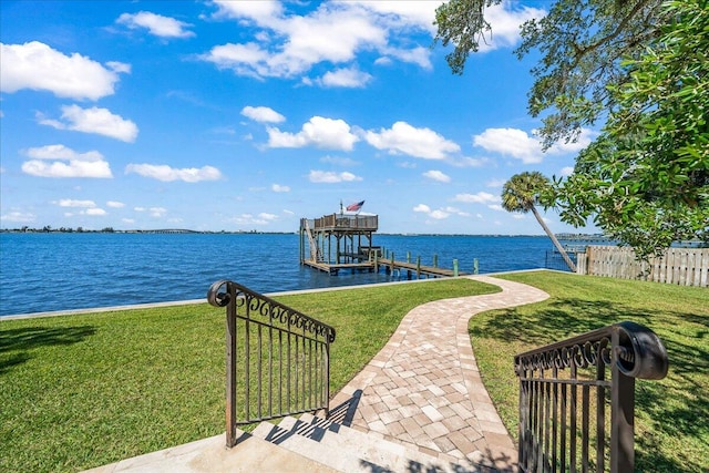 dock area with a water view and a lawn