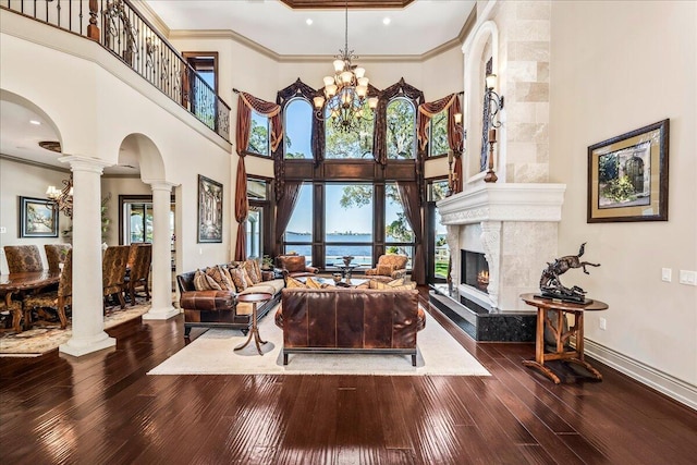 living room with a water view, a premium fireplace, a high ceiling, and hardwood / wood-style floors