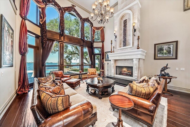 808 N Riverside Dr, Indialantic, FL 32903 - living room featuring a high ceiling, baseboards, a premium fireplace, a chandelier, and hardwood / wood-style flooring
