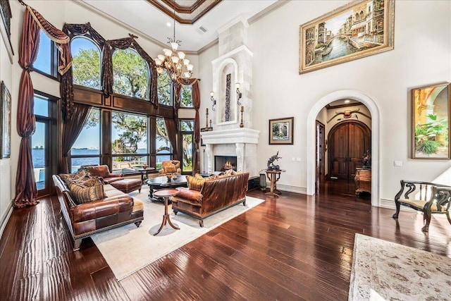 808 N Riverside Dr, Indialantic, FL 32903 - living room with a towering ceiling, crown molding, arched walkways, hardwood / wood-style flooring, and baseboards