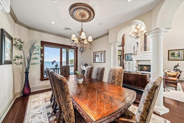 808 N Riverside Dr, Indialantic, FL 32903 - dining area with ornate columns, a chandelier, arched walkways, crown molding, and wood finished floors