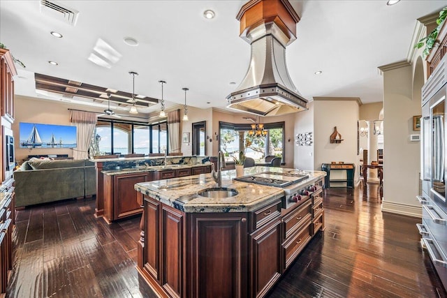 808 N Riverside Dr, Indialantic, FL 32903 - kitchen with a kitchen island with sink, stainless steel gas stovetop, open floor plan, a sink, and dark wood-style flooring