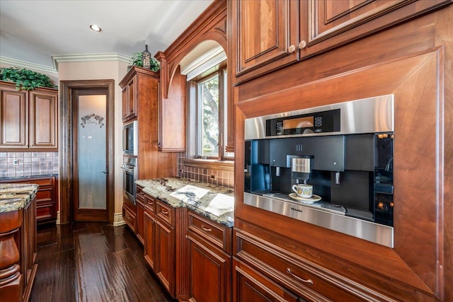 kitchen with dark wood-type flooring, backsplash, crown molding, and light stone countertops