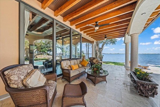 view of patio / terrace with an outdoor living space, a water view, and ceiling fan