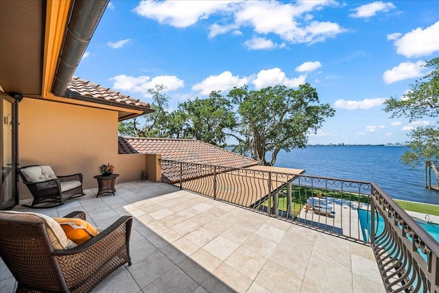 view of patio / terrace with a water view and a balcony