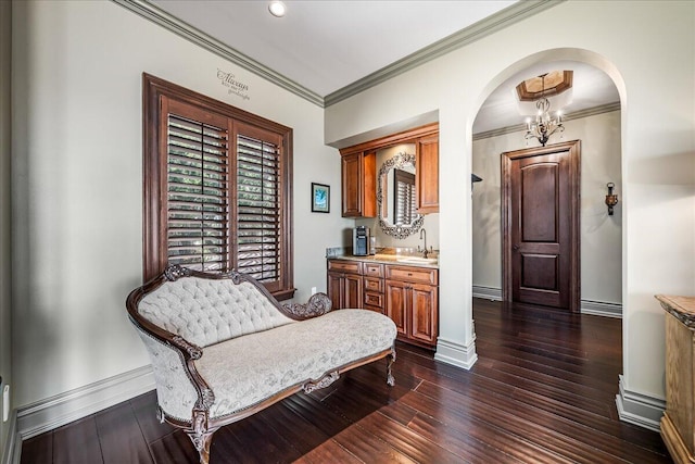 sitting room with sink, ornamental molding, dark hardwood / wood-style flooring, and an inviting chandelier