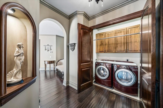 clothes washing area with cabinets, dark hardwood / wood-style floors, washer and clothes dryer, and ornamental molding