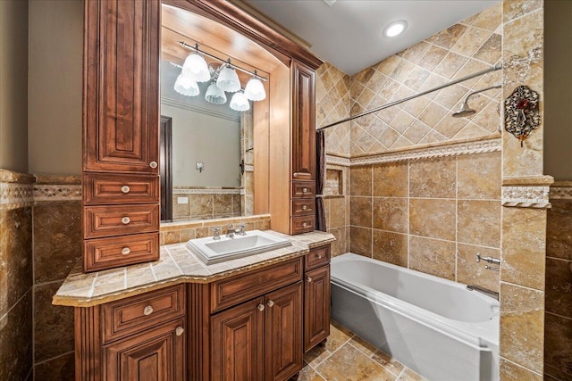 bathroom with tiled shower / bath, tile walls, and vanity