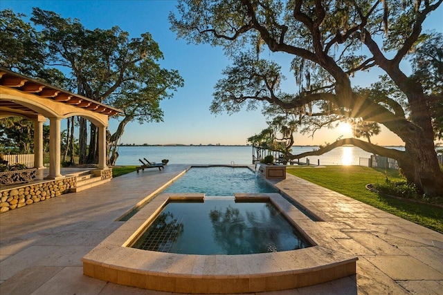 view of swimming pool featuring a water view, an in ground hot tub, and a patio area