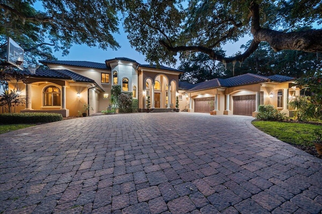 808 N Riverside Dr, Indialantic, FL 32903 - mediterranean / spanish-style home with a garage, decorative driveway, stucco siding, and a tiled roof