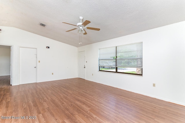 unfurnished room featuring ceiling fan, wood-type flooring, a textured ceiling, and vaulted ceiling