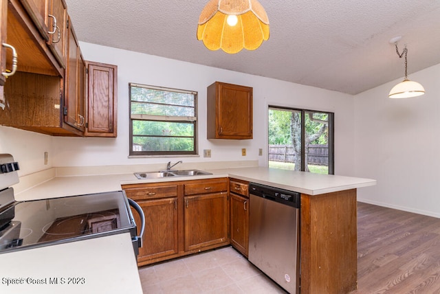 kitchen with kitchen peninsula, sink, dishwasher, white electric range, and hanging light fixtures