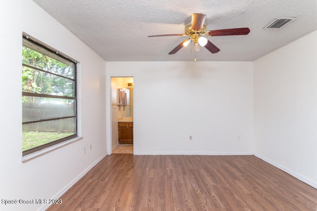 spare room with ceiling fan, a textured ceiling, and hardwood / wood-style flooring