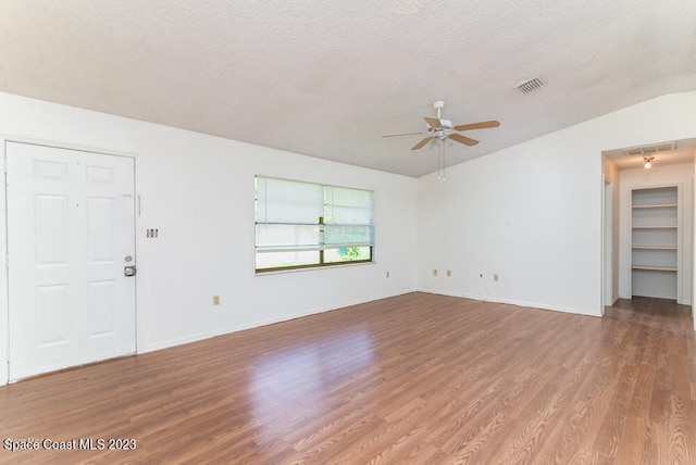 unfurnished living room featuring hardwood / wood-style floors, ceiling fan, a textured ceiling, and vaulted ceiling