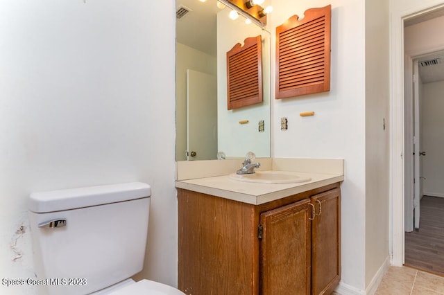 bathroom featuring wood-type flooring, vanity, and toilet