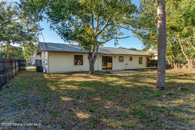 rear view of house featuring a yard and central AC