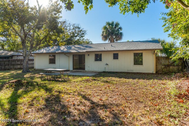 rear view of property featuring a lawn and a patio