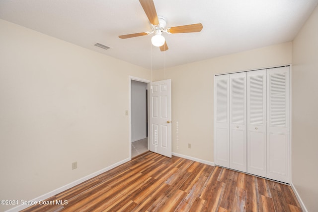 unfurnished bedroom featuring ceiling fan, a closet, and dark hardwood / wood-style flooring