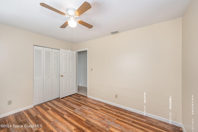 unfurnished bedroom featuring ceiling fan, wood-type flooring, and a closet