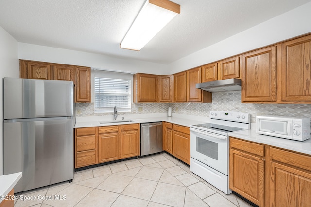 kitchen featuring light tile patterned floors, sink, backsplash, a textured ceiling, and stainless steel appliances