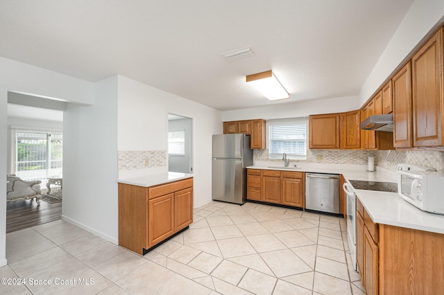 kitchen with sink, stainless steel appliances, decorative backsplash, and light tile patterned floors