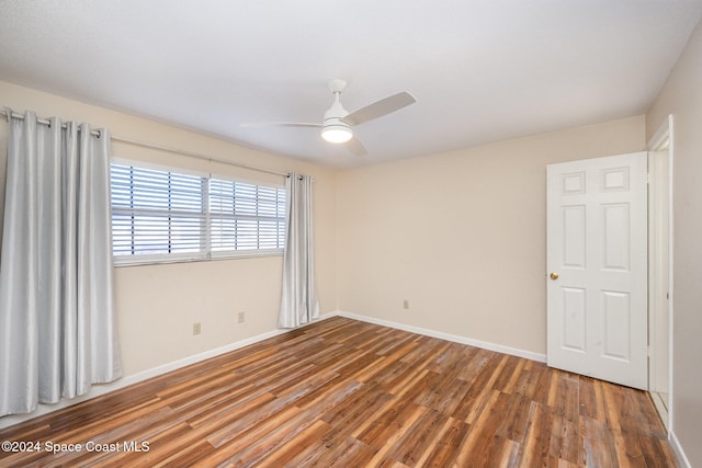 empty room with hardwood / wood-style flooring and ceiling fan