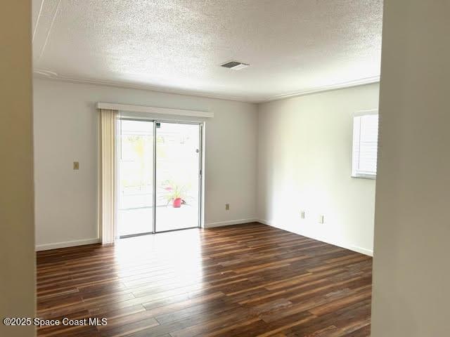 unfurnished room featuring a textured ceiling and dark wood-type flooring