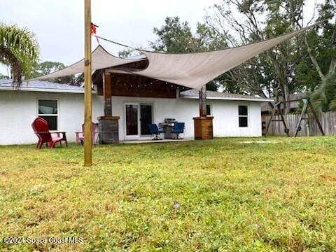 rear view of property featuring a patio area and a yard