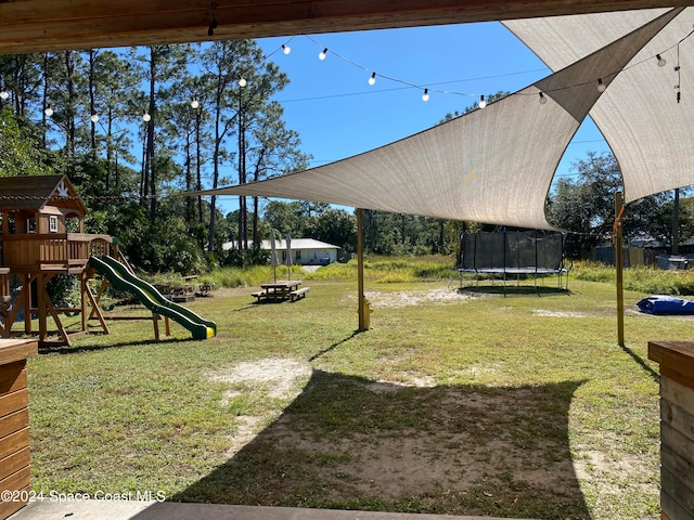 view of yard featuring a playground and a trampoline