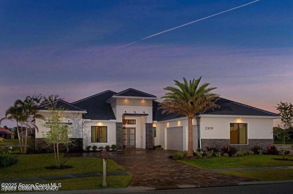 view of front of house featuring a garage and a yard