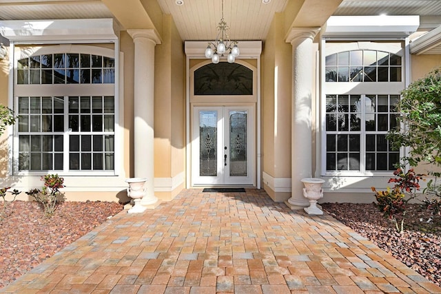 entrance to property featuring stucco siding and french doors