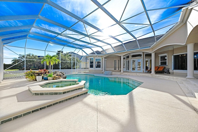 view of swimming pool featuring french doors, a lanai, a pool with connected hot tub, and a patio area