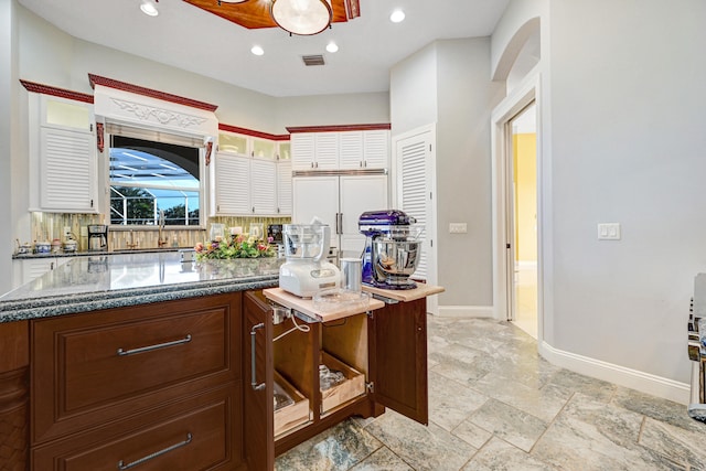 kitchen featuring tasteful backsplash and dark stone counters