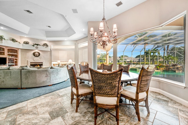 dining area with a notable chandelier and a raised ceiling