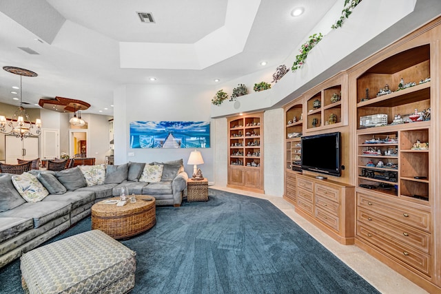 living room featuring built in features, a tray ceiling, and a chandelier