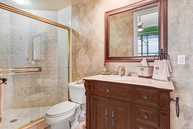 bathroom featuring vanity, a shower stall, and toilet