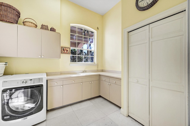 washroom with sink, light tile patterned floors, washer / clothes dryer, and cabinets