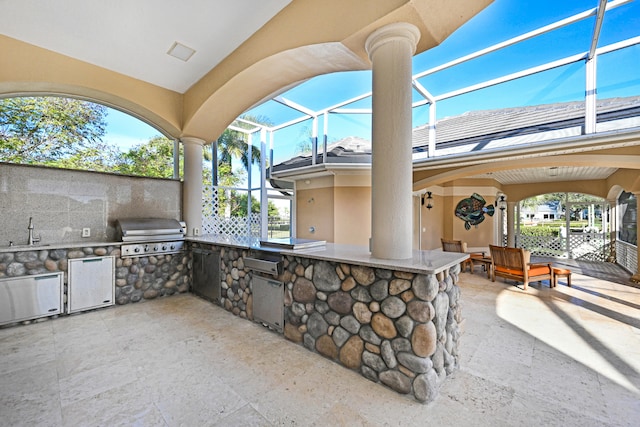 view of patio featuring exterior kitchen, a lanai, sink, and a grill