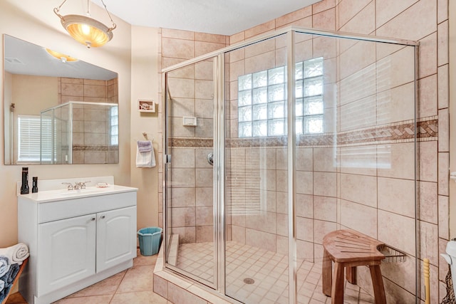 full bathroom with tile patterned flooring, vanity, and a shower stall