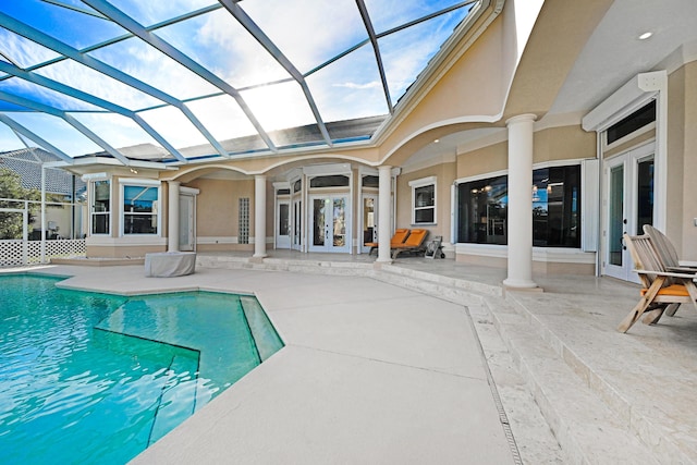 outdoor pool featuring glass enclosure, a patio area, and french doors