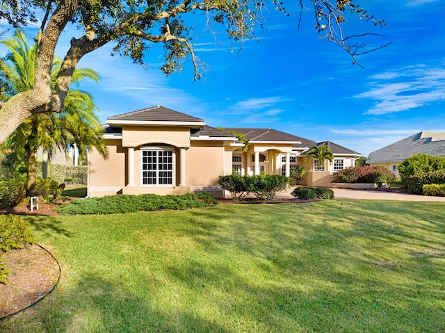 view of front of property with stucco siding and a front lawn