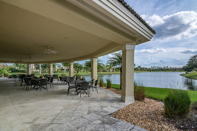 view of patio featuring a water view and ceiling fan