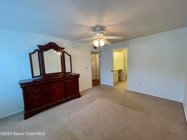 unfurnished bedroom featuring ceiling fan, a textured ceiling, connected bathroom, and light carpet