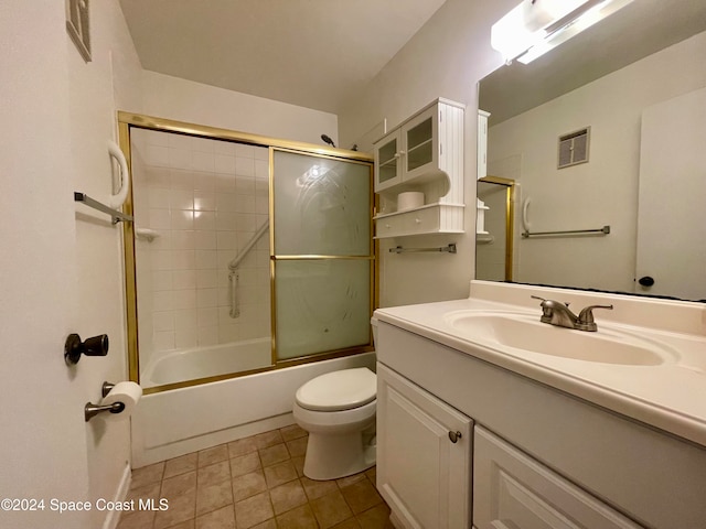 full bathroom featuring combined bath / shower with glass door, tile patterned floors, vanity, and toilet