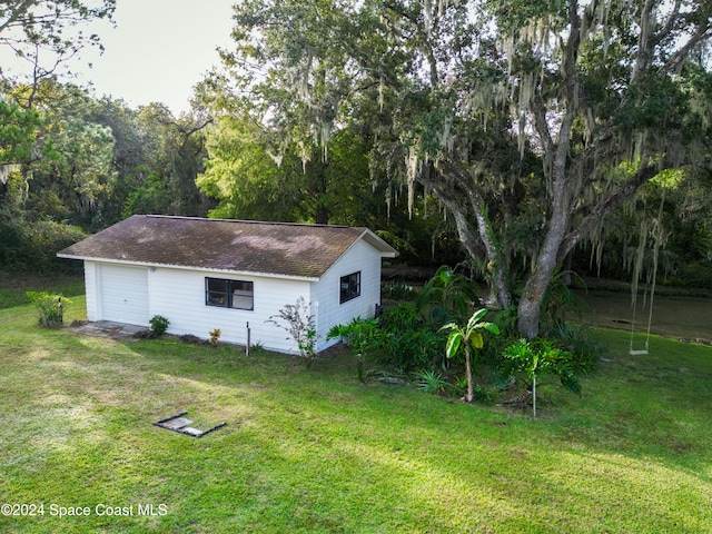 view of side of property with a yard and a garage